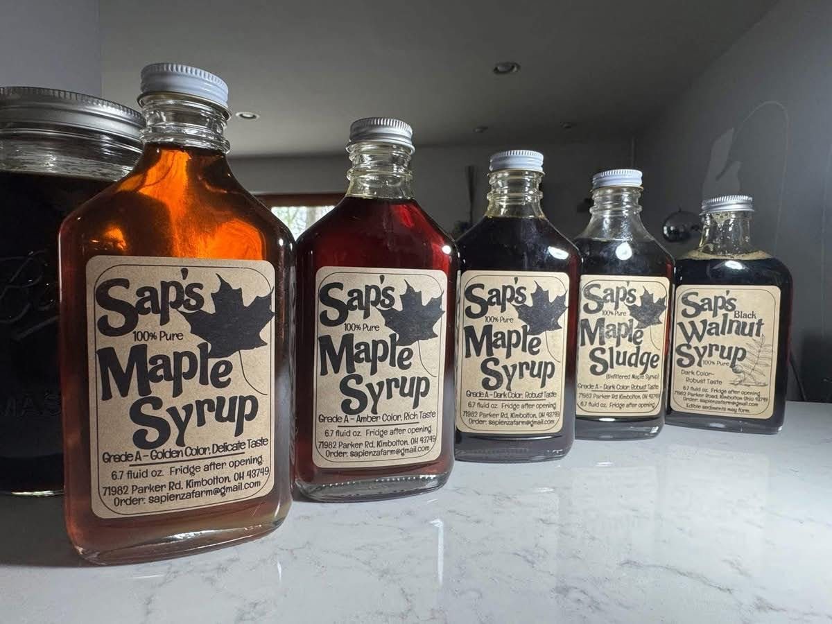 Five bottles of Sap's syrup in a row, from golden maple syrup to dark