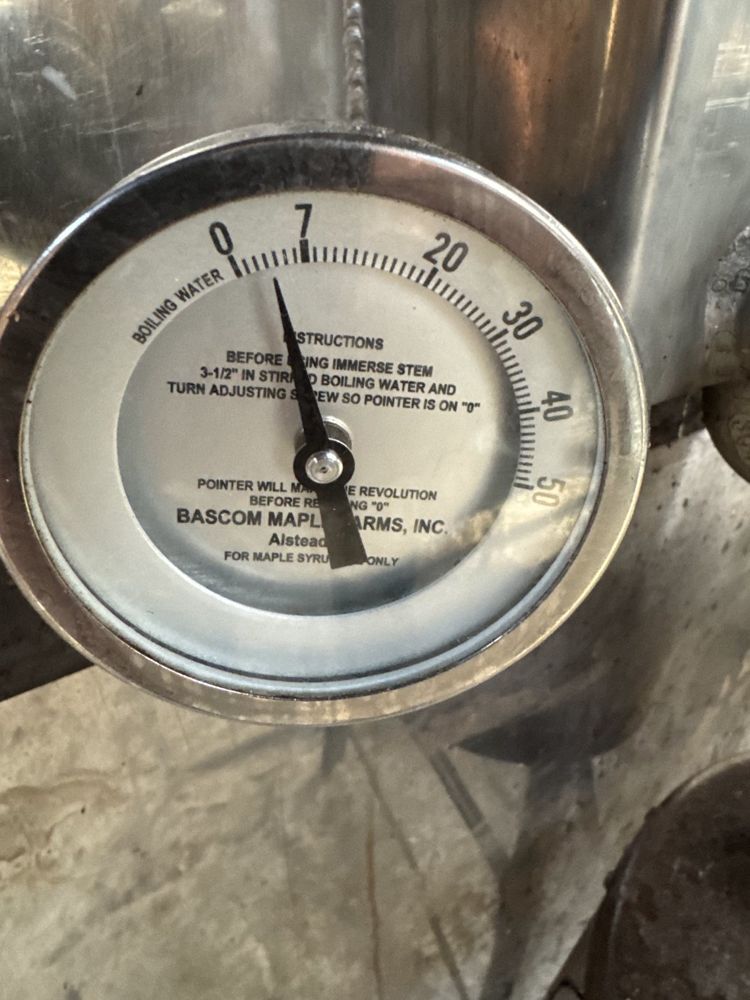 A boiling-water thermometer dial mounted on the stainless steel evaporator